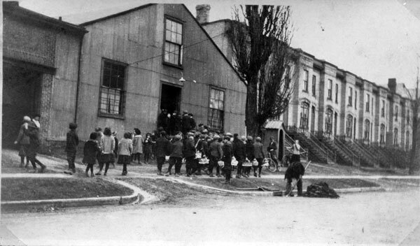 Children bringing Easter gifts to the battalion. (Photo: Gordon C. Eby, Mennonite Archives of Ontario CA MAO Hist.Mss.1.66.4.1-028, Apr 1916) Caption in album by Anne Eby Millar: "In April 1916, the 118th Battalion was stationed on Courtland Avenue, Kitchener. Local schoolchildren marched to their headquarters to bring them Easter eggs. Always fond of children, Gordon took this opportunity to get some pictures."